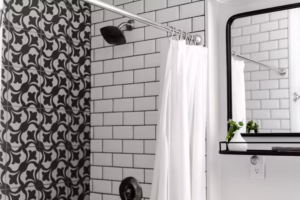 Shower trends 2024 featuring bold statement tiles with black and white patterns, paired with subway tiles, creating a modern and artistic shower design.